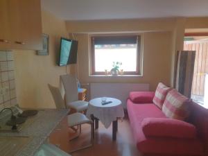 a living room with a pink couch and a table at Ferienwohnung Kreisel direkt in Bad Kösen in Bad Kösen