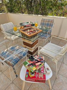 a glass table with books and drinks on a patio at Sophy's Cottage in Politika