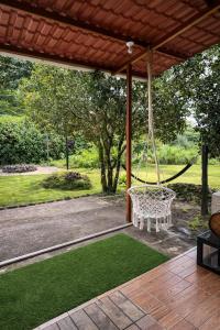 a porch with a swing and a yard with grass at Amancay House, Jacuzzi and Pool in San Cristóbal