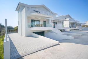 a large white house with stairs in front of it at Hibiscus Suites in Potos