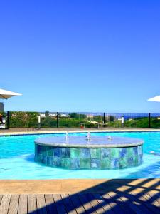 a swimming pool with blue water and aizonsizons at Spacious 3 Bedroom Apartment in Ballito Hills Lifestyle Estate Near Ballito Beach in Ballito