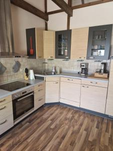 a kitchen with white cabinets and wooden floors at Monteurs Wohnung in Andervenne in Andervenne Oberdorf