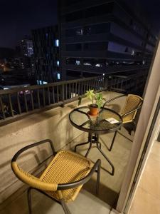 a table and chairs on a balcony at night at Depto cómodo y central in Temuco