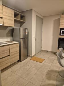 a kitchen with a stainless steel refrigerator and cabinets at Depto cómodo y central in Temuco