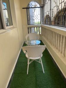 a balcony with two chairs and a glass table at Honned homes in Mombasa