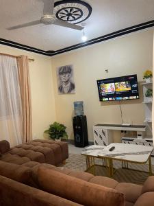 a living room with a couch and a flat screen tv at Honned homes in Mombasa