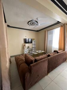 a living room with a large brown couch at Honned homes in Mombasa +5 photos