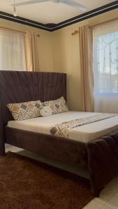 a large bed in a room with a window at Honned homes in Mombasa