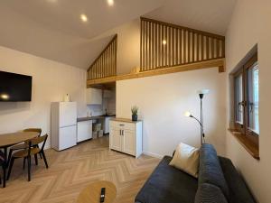 a living room with a couch and a table and a kitchen at Domki Mazury Mikołajki in Mikołajki +8 photos
