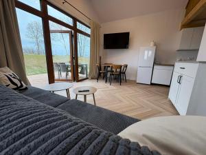 a bedroom with a bed and a kitchen and a table at Domki Mazury Mikołajki in Mikołajki