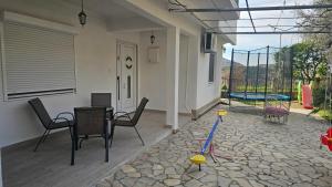 a patio with a table and chairs and a playground at Guest house Boljević in Rap