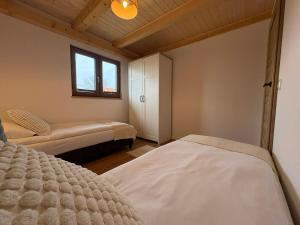 a bedroom with two beds and a window at Domki Mazury Mikołajki in Mikołajki