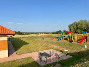 a view of a playground with chairs and a table at Domki Mazury Mikołajki in Mikołajki