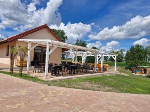 a pavilion with tables and chairs on a patio at Domki Mazury Mikołajki in Mikołajki