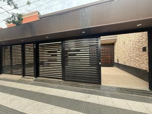 a building with two garage doors and a sidewalk at Hotel Haití in San Miguel de Tucumán