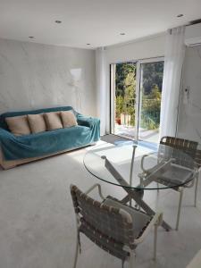 a living room with a glass table and a couch at Maison vue mer a 5 min de MONACO in Roquebrune-Cap-Martin