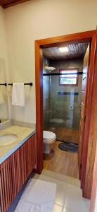 a bathroom with a toilet and a glass shower at Vila Baião - Casa Luiz Gonzaga in Itacaré