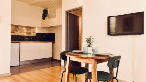 a kitchen and dining room with a wooden table and chairs at Dubonnet - Cœur de ville in Brignoles