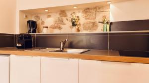 a kitchen with white cabinets and a sink at Dubonnet - Cœur de ville in Brignoles