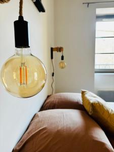 a glass lamp hanging from a wall next to a couch at Dubonnet - Cœur de ville in Brignoles