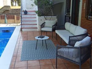 a patio with a couch and chairs next to a pool at Casa Azahar in Lliria