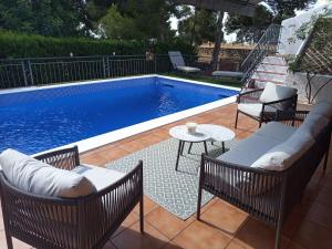 a swimming pool with chairs and a table next to it at Casa Azahar in Lliria