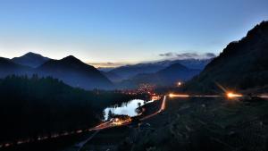 a night view of a valley with a river and mountains at Residence Hotel Miralago in Pergine Valsugana