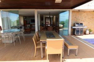a patio with a table and chairs on a deck at Porto Brasil Resort - Casa de praia em condomínio de luxo in Parnamirim