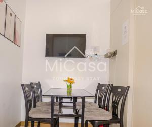 a table with chairs and a vase of flowers on it at MiCasa South Residences Cozy & Affordable Stay in Manila