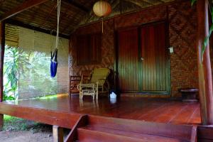 a porch of a house with a table and chairs at Andaman Sunflower in Ko Lanta