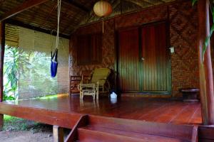 un porche de una casa con mesa y sillas en Andaman Sunflower en Ko Lanta
