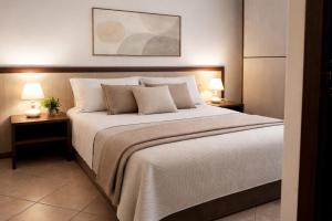 a bedroom with a large bed with two lamps at Domo - Guest-House Il Nespolo Fiorito in Orosei