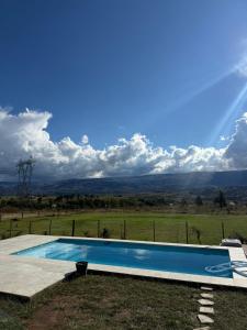 a swimming pool with a view of a field at El Tesoro de Yacanto in Villa Yacanto