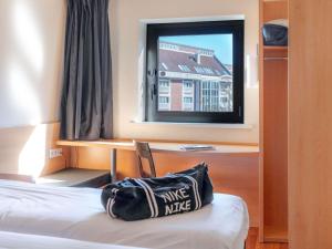 a hotel room with a bag on a bed and a window at ibis Lille Centre Gares in Lille +160 photos