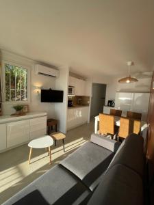 a living room with a couch and a table at Appartement vue mer Domaine Les Restanques Grimaud in Grimaud
