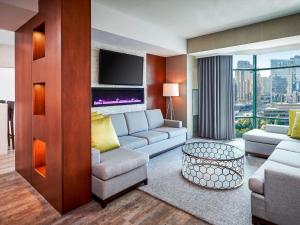 a living room with a couch and a tv at Novotel Toronto North York in Toronto