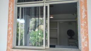 a window of a house with a plant at Quarto privativo em casa compartilhada in Aracaju