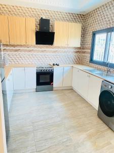 a kitchen with white cabinets and a stove at Amie's Villa Apartment in Jarbang