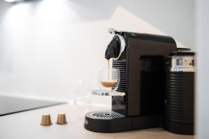 Eine Kaffeemaschine gießt ein Getränk in ein Glas. in der Unterkunft LaMiaCasa City 145 qm 2 Baths Parking in Stuttgart + 19 Fotos