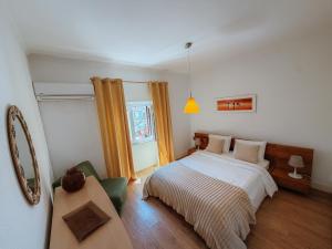 a bedroom with a bed and a table and a window at Villa Frescura do Mar by Casas de Setúbal in Setúbal