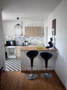 a kitchen with a counter and two bar stools at Villa Juliette in Le Tréport