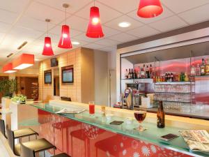 a bar in a restaurant with red lights at Ibis Le Havre Sud Harfleur in Harfleur
