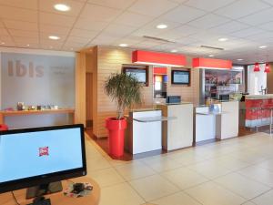 a waiting area of a ups store with a computer monitor at Ibis Le Havre Sud Harfleur in Harfleur