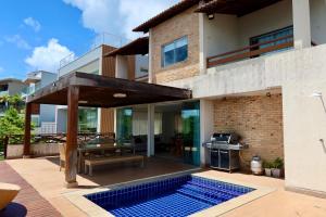 a house with a swimming pool and a patio at Porto Brasil Resort - Casa de praia em condomínio de luxo in Parnamirim