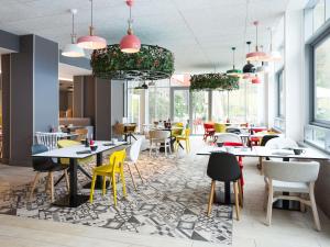 a restaurant with tables and chairs and windows at Novotel Resort & Spa Biarritz Anglet in Anglet