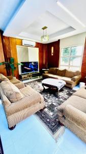 a living room with two couches and a tv at فيلا الكينج مريوط in King Mariout