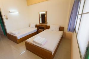 two beds in a small room with a mirror at Mont Talay Hotel in Prachuap Khiri Khan +9 photos