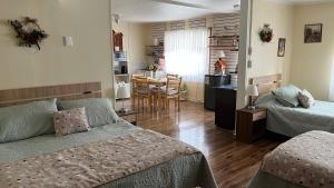 a bedroom with a bed and a kitchen with a table at MI HOGAR ES TUYO in Punta Arenas