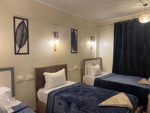 a room with two beds with blue and white sheets at Backpackers Room 3 in Naj‘ al Maḩaţţah