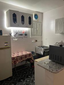 a kitchen with a refrigerator and a counter with a table at Backpackers Room 3 in Naj‘ al Maḩaţţah +13 photos